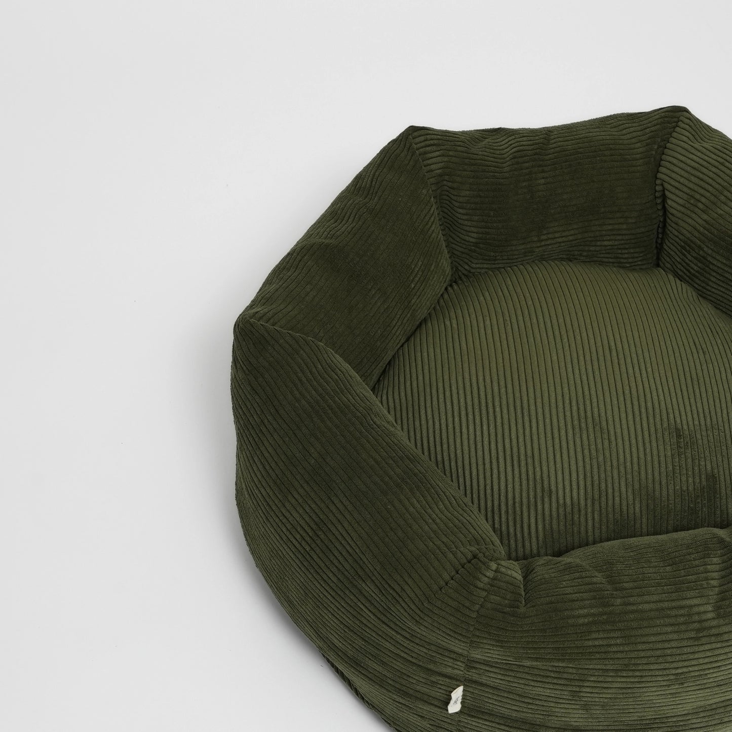 Green ribbed pet bed on a light gray background