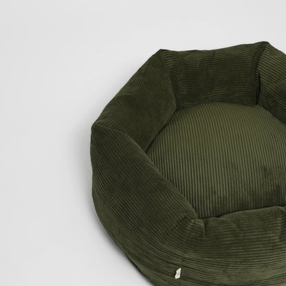 Green ribbed pet bed on a light gray background