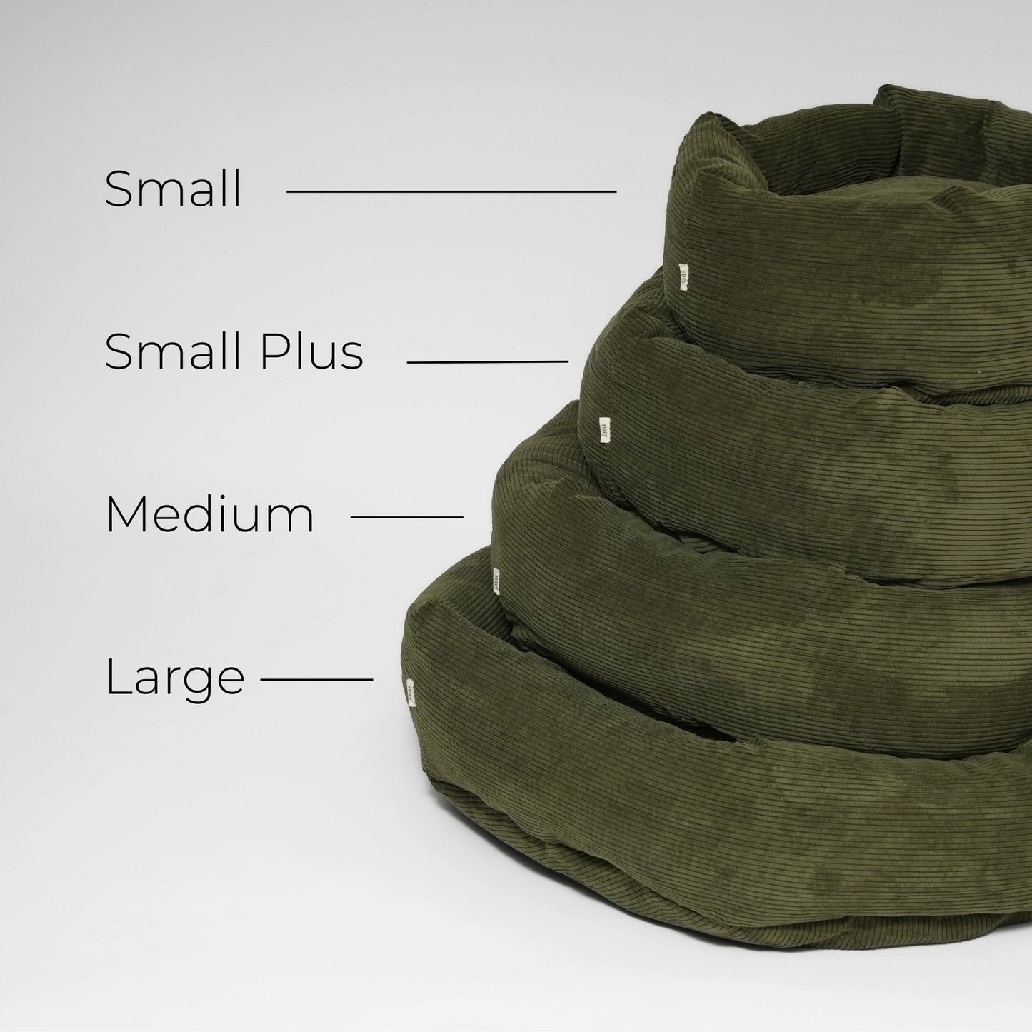 Stack of green pet beds with size labels on a white background