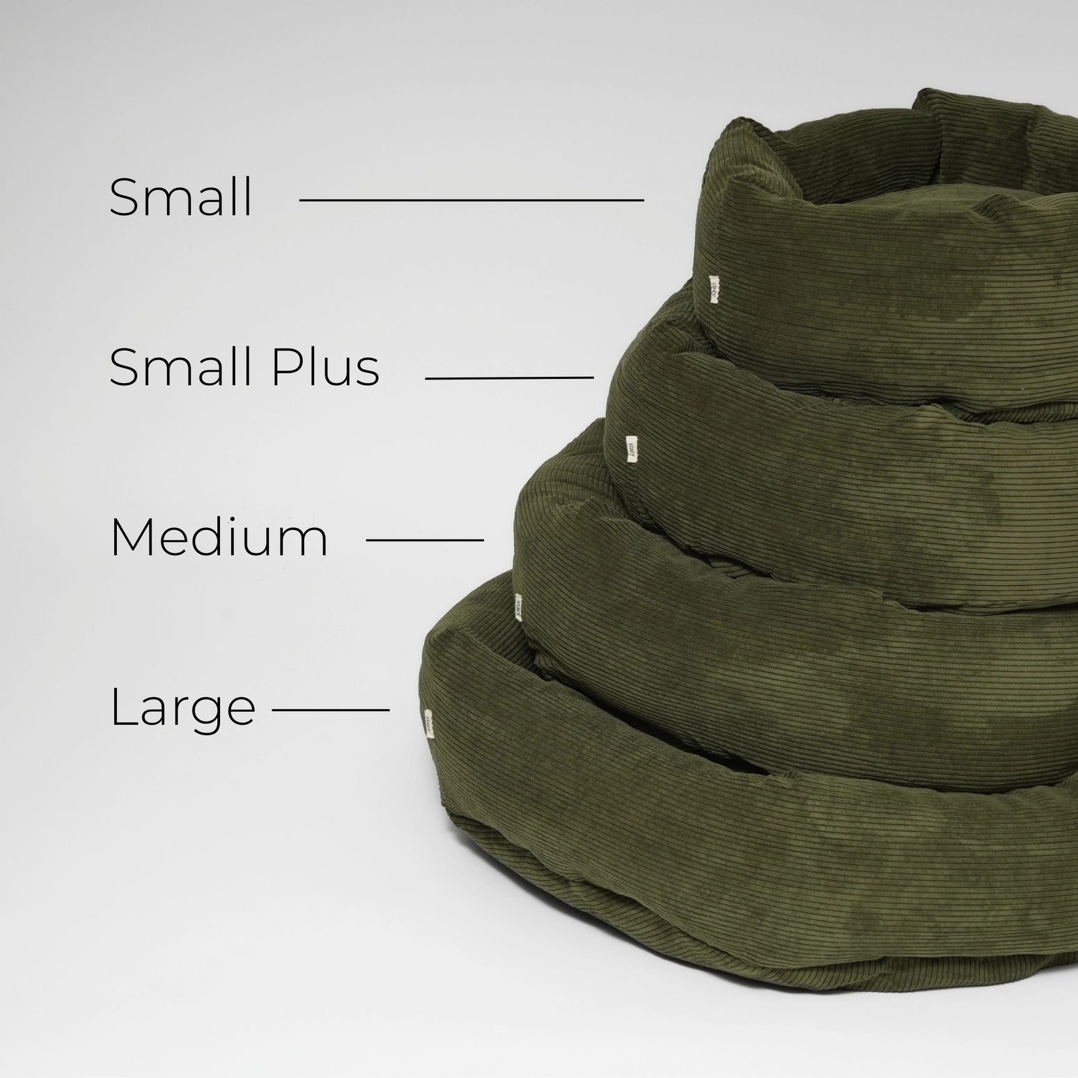 Stack of green pet beds with size labels on a white background