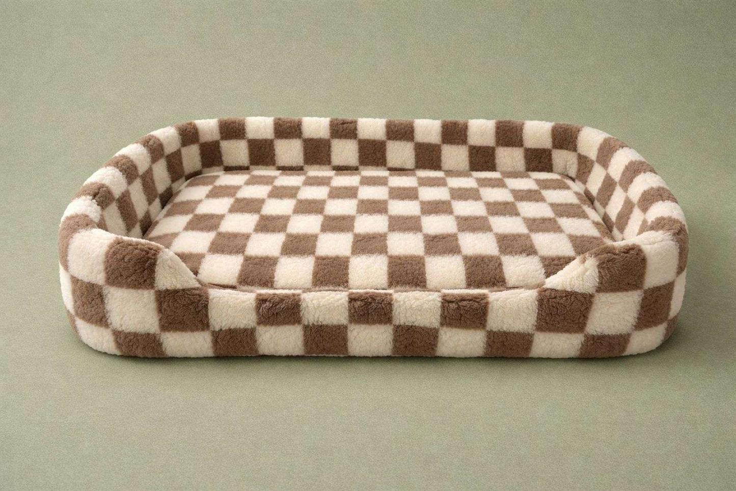 A plush rectangular pet bed with a brown and cream checkered pattern, shown on a solid muted green background.
