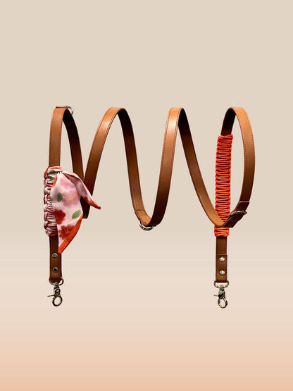 Two leather straps with floral and red accents on a beige background