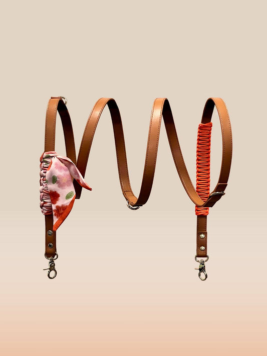 Two leather straps with floral and red accents on a beige background