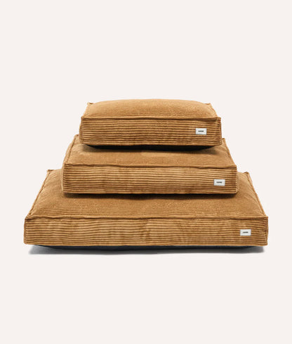 Stack of brown corduroy folded blankets on a white background