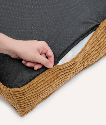 Person holding a black mattress cover with brown trim on a white background