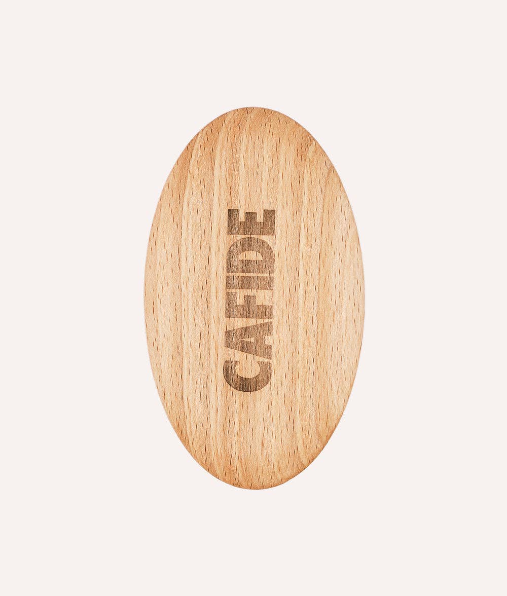 Wooden oval object with 'CAFIDE' engraving on a light beige background