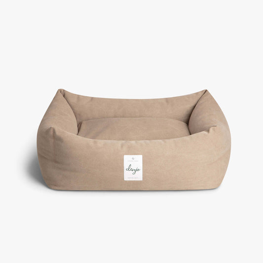 Beige pet bed with a visible brand label on a white background