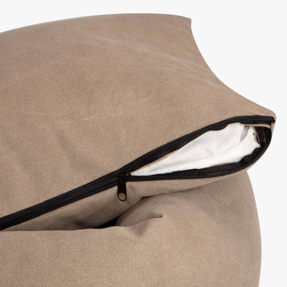 Close-up of a beige pillow with a zipper on a white background