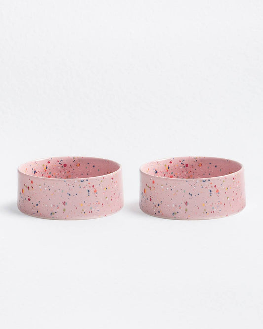 Two pink bowls with speckled pattern on a white background