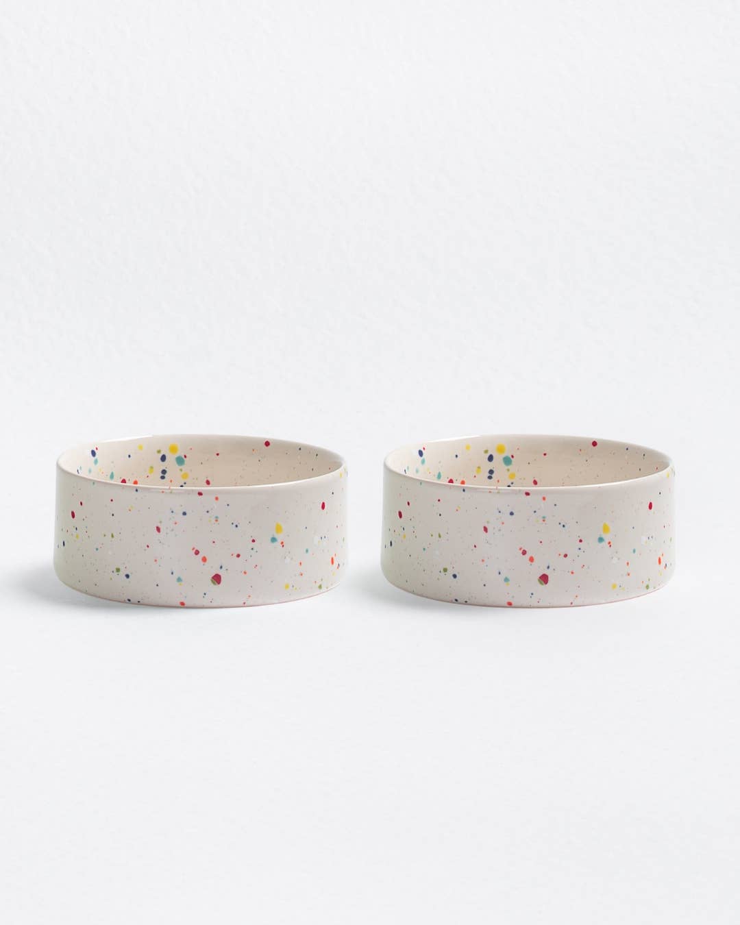 Two ceramic bowls with colorful speckles on a white background