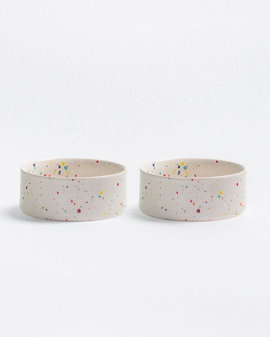 Two ceramic bowls with colorful speckles on a white background