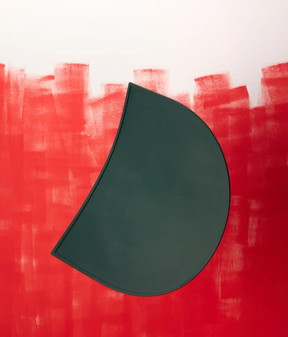 Dark green half-circle silicone mat on a red and white abstract background