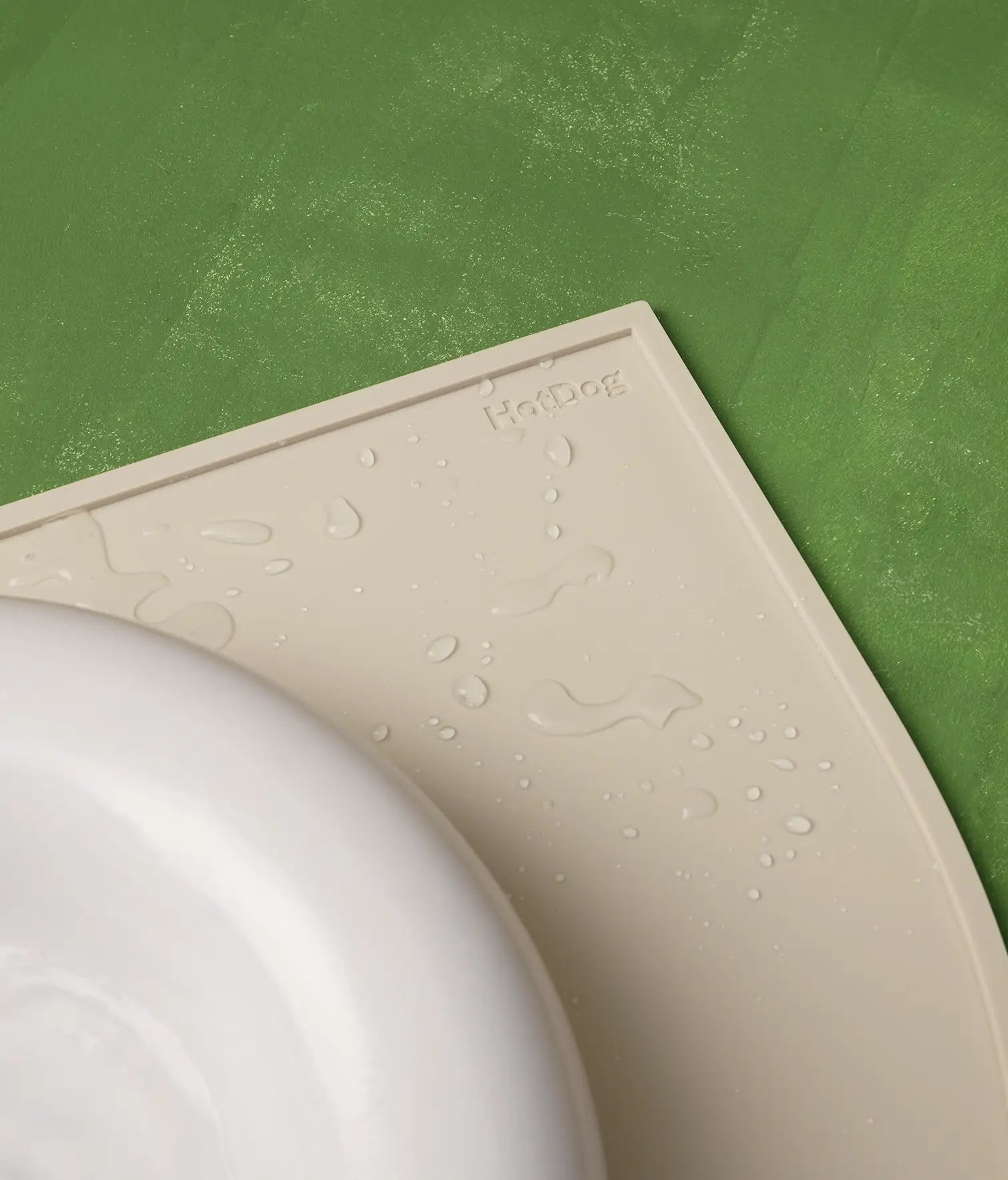 Beige mat with a brand logo on a green surface