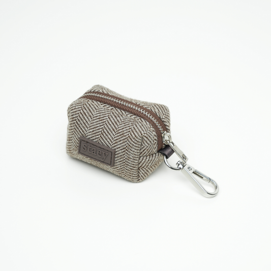 Small herringbone-patterned pouch with a zipper and keychain clip on a white background