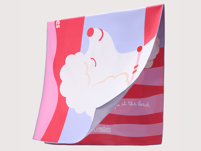 Colorful towel with a cartoon design of a beach scene on a light gray background