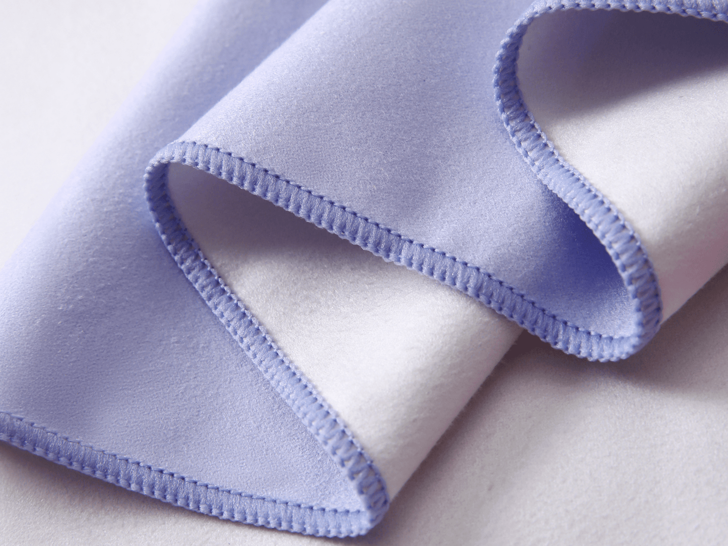 Close-up of a folded fabric with purple edge on a light background