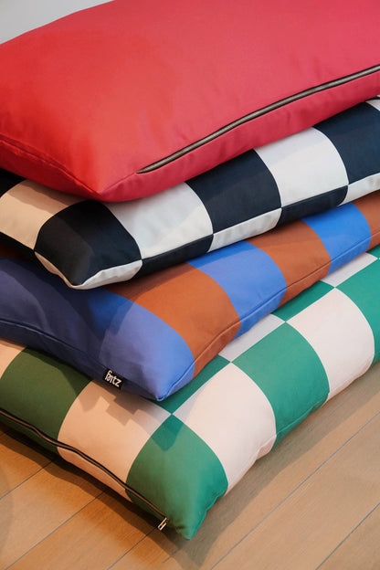 Stack of colorful checkered pillows on a wooden floor