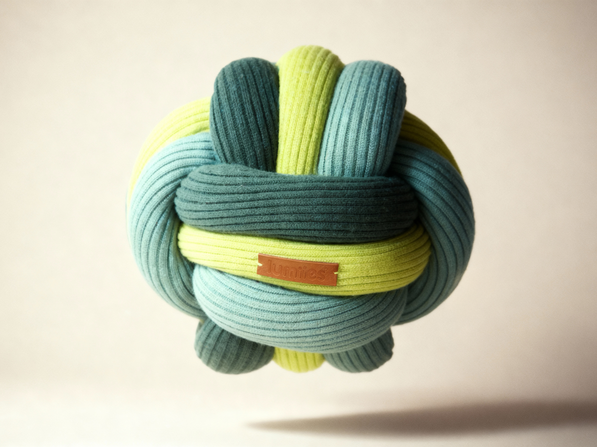 Colorful knotted toy with a brand label on a beige background