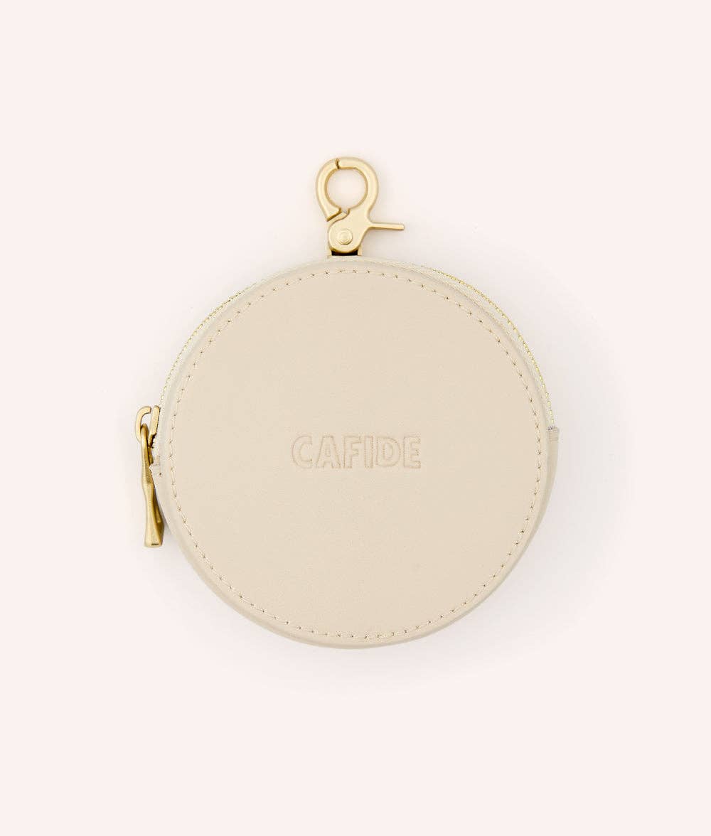 Round beige dog treats bag with gold zipper and clasp on a white background