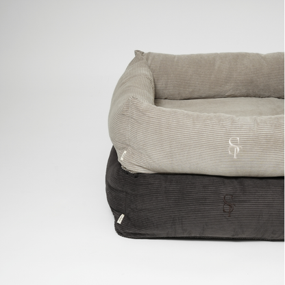 Two corduroy pet beds, one gray and one black, stacked on a white background.