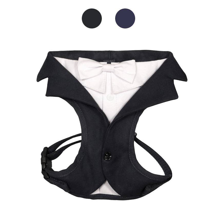 Black tuxedo-style dog harness with a white bow tie on a white background