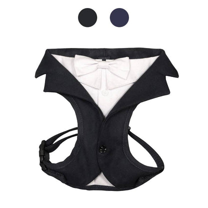 Black tuxedo-style dog harness with a white bow tie on a white background
